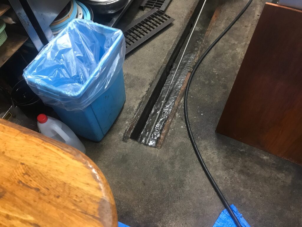 まずは土間の側溝から高圧洗浄です。管にこびりついた汚れを剥がします。